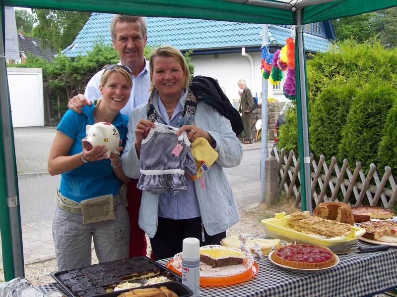 Bürgermeister Volker Popp und seine Frau Akki mit Stephanie Gergely (mit Spendenschwein) beim 1. Straßenfest im Niendorfer Aalweg (Foto: RK)